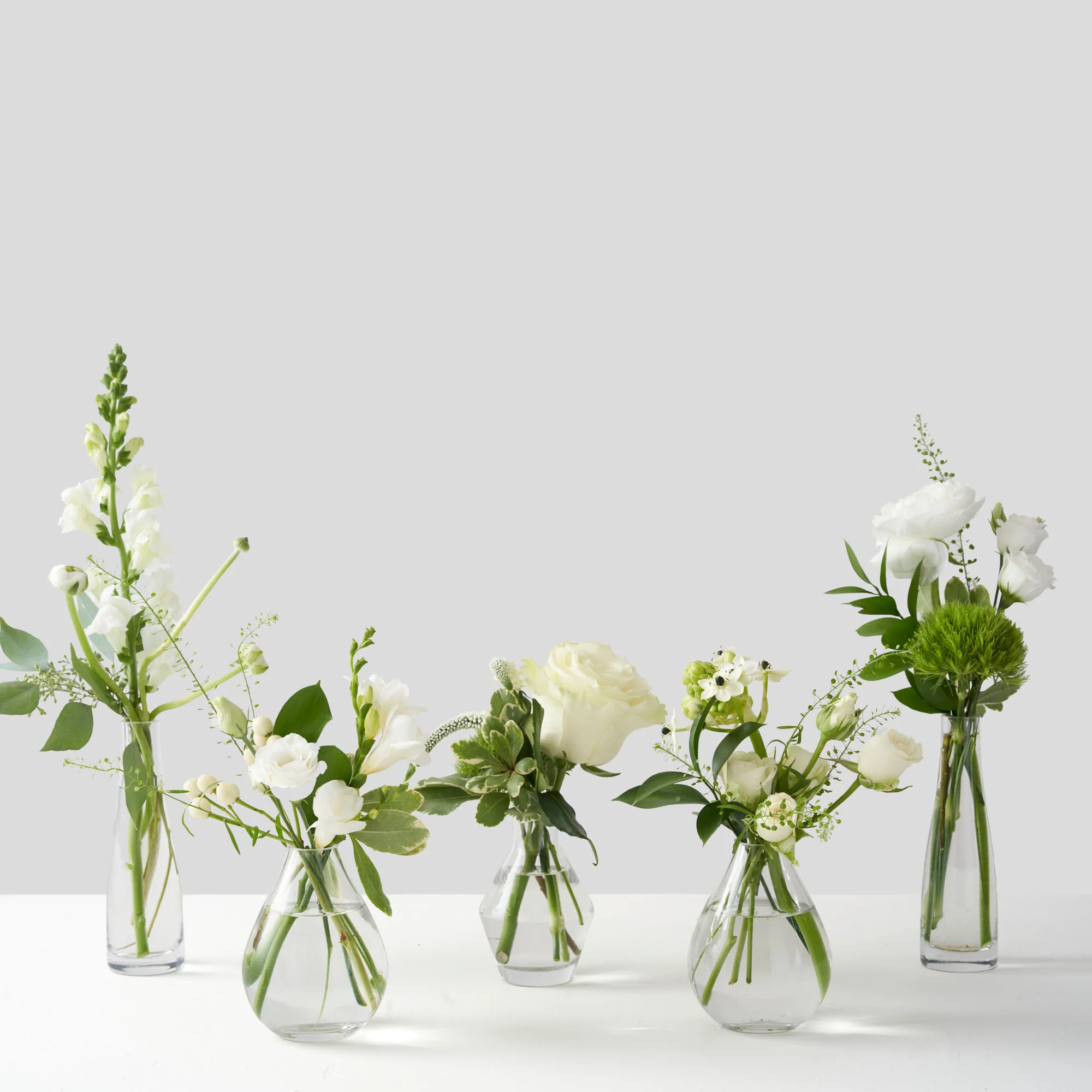 Simple ceramic bud vases styled on a shelf