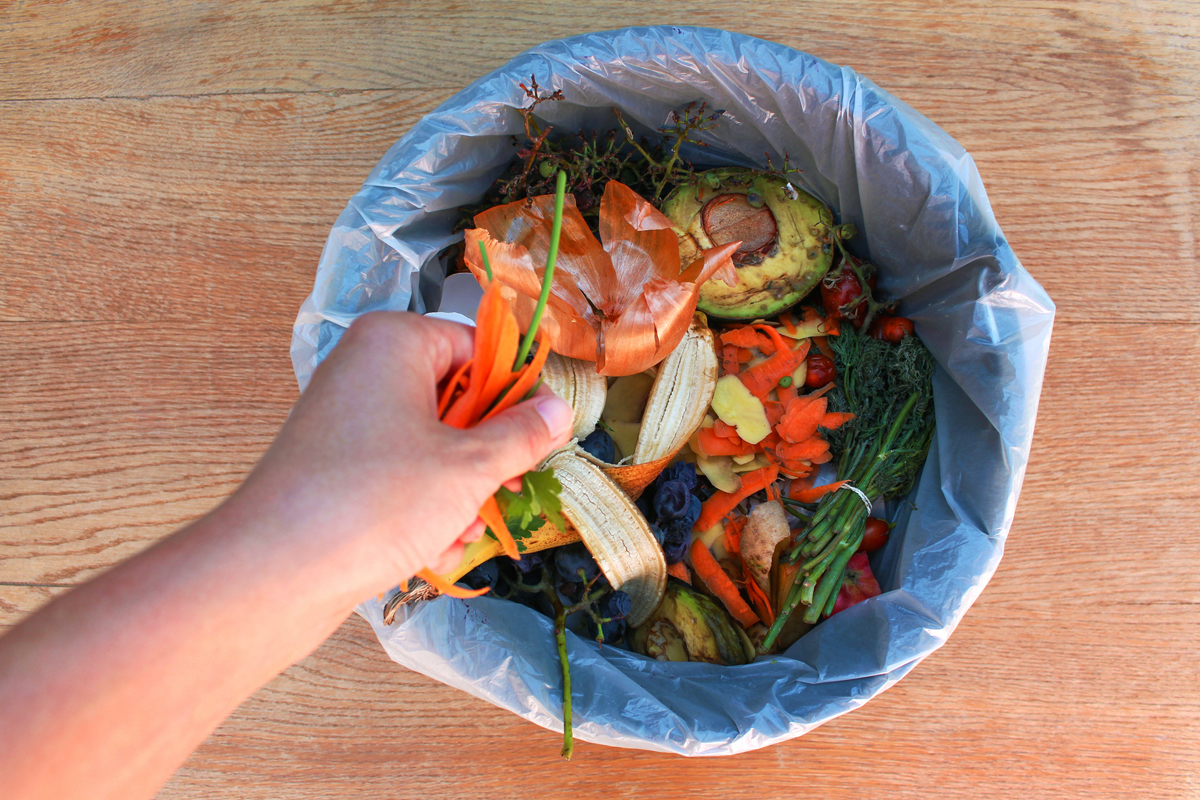 Vegetable scraps beside a cutting board